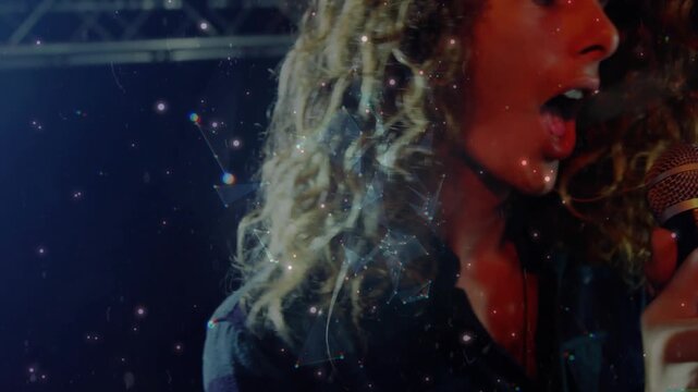 Lead singer singing, leaning into mic causing orb growing into starry bubble, expressing music