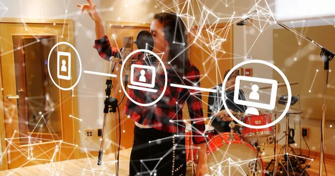 Singing vocalist in plaid and headphones, leaning into mic in studio with drums and network overlay