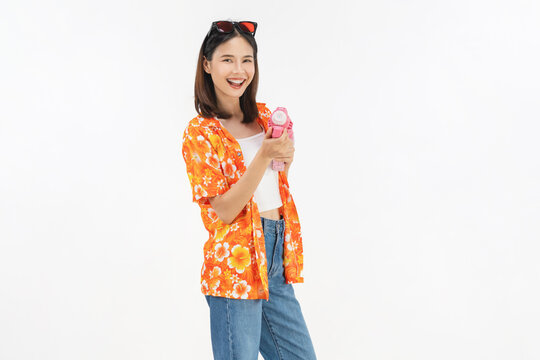 Songkran festival in Thailand, Cheerful young woman wearing summer wearing floral shirt with a pink toy gun isolated on white background.