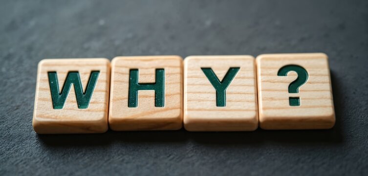 Wooden blocks spell out the word WHY with a question mark on a dark textured surface. This represents inquiry, doubt, or the need for explanation in life or business.