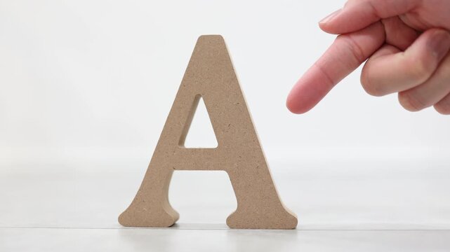 アルファベット置物を指さす・木製Aの文字・指示する手元