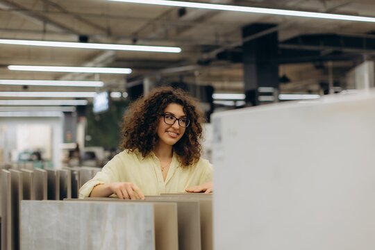 Happy woman choosing tiles for home renovation