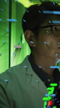 Vertical video: Blue-green streaks appearing, Korean lab tech turning right inspecting green racks