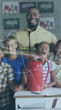 Vertical video: Teacher showing extinguisher kids laughing light trails sweeping for safety demo