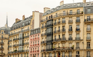 Fototapeta premium Haussmann architecture in Paris, typical street with classic apartment buildings and diverse balconies