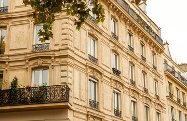 Obraz premium Ornate Haussmann architecture on a classic Parisian building facade, featuring balconies and windows in autumn light