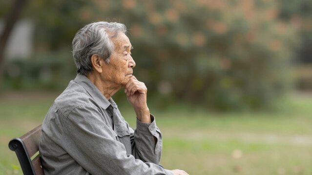 Contemplative Senior Asian Man in Outdoor Park