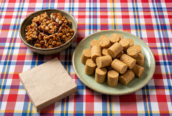 Doces típicos brasileiros de Festa Junina com paçoca e pé de moleque sobre toalha xadrez
