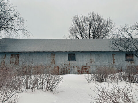 Une grange en hiver Qu&eacute;bec, Canada. Ferme abandonn&eacute;e en hiver, sous la neige, avec des arbres d&eacute;nud&eacute;s.