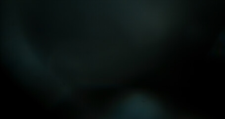 Obraz premium Abstract cinematic lens flare with bright light burst and star rays, isolated on black background. Optical light effect ideal for VFX overlays, transitions, titles and dramatic visual accents.