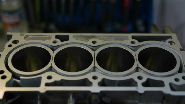 Close-up view of an aluminum engine block with empty cylinders.