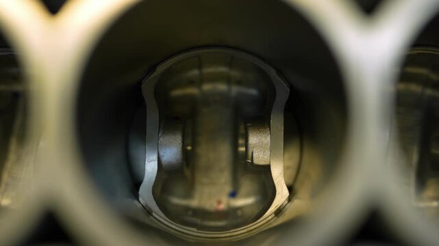 Internal view of a metal piston inside an engine cylinder.
