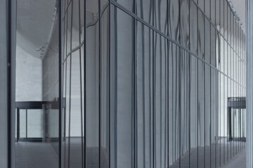 Obraz premium Glass facade detail with reflections on modern building exterior surface. Transparent panels showing structural lines and mirrored urban environment.