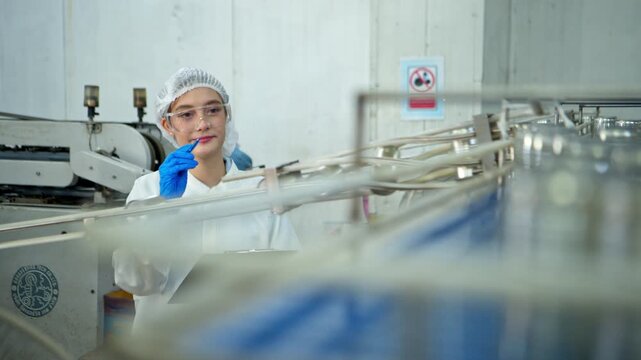 The production supervisor is inspecting and controlling the operation of packaging line of the canned fish processing plant