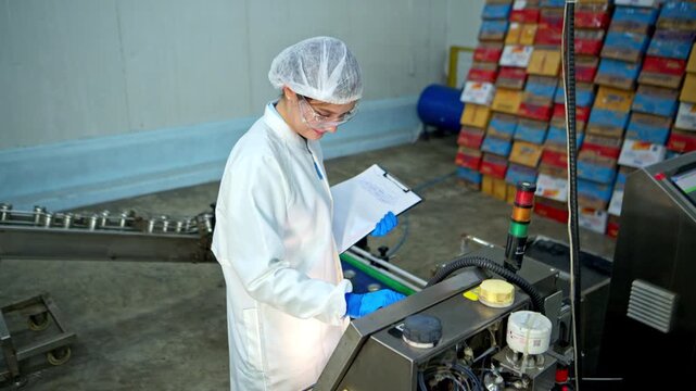 The production supervisor is inspecting and controlling the operation of packaging line of the canned fish processing plant
