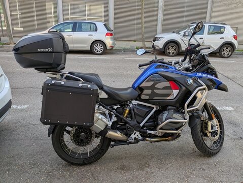 Vista lateral de moto BMW Adventure R 1250 GS con portaequipajes estacionada en Madrid, Espa&ntilde;a, 25 de febrero de 2026