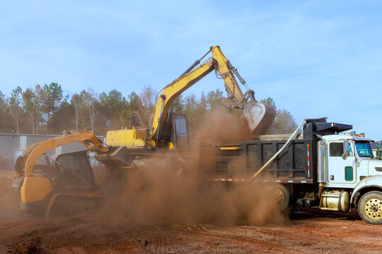 Heavy machinery removes dirt loads it into truck on construction site in rural area