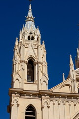 Obraz premium Majestic cathedral towers touch the vibrant blue skies of Malaga, Spain, showcasing exquisite architectural beauty and cultural heritage