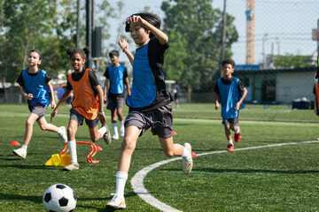 Group of international school kids playing soccer together on the field