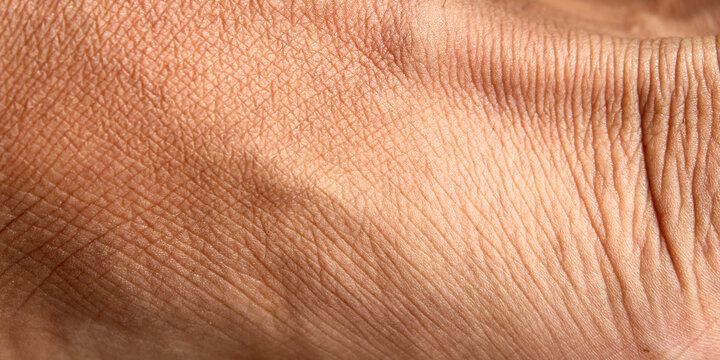 Detailed texture of men's feet, showing natural lines, fine wrinkles and epidermis structure in depth