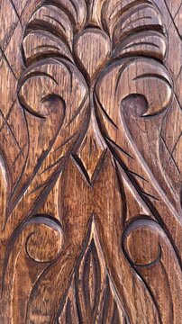 Close up of ornate detailed wood carving featuring leaf and scroll motifs