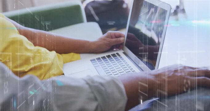 Animation of data processing over mid section of male and female colleagues using laptop at office