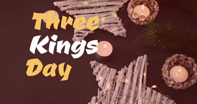 Animation of three kings day text banner over burning candles and christmas decorations