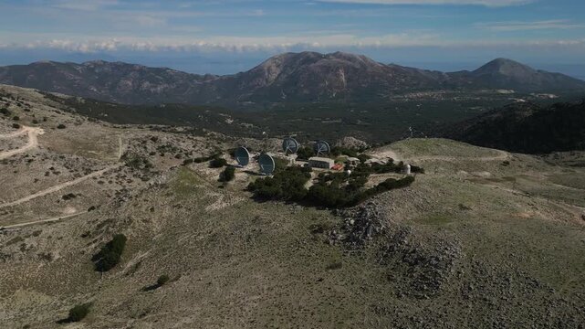 Satellite dish array on a remote, rocky mountaintop.