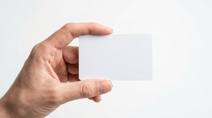 Obraz premium A hand holding a blank white card against a clean white background, presented in a simple, minimalist style with a bright and airy mood.