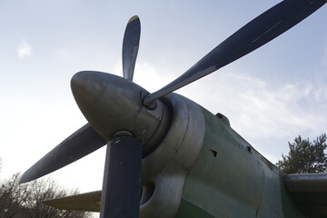 Close-up of a vintage military aircraft nose and propeller against the sky. Aviation and flight concept © Uladzimir
