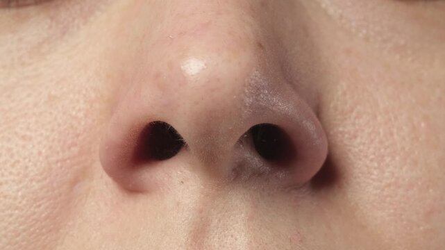 Close up shot of a Slavic woman demonstrating nostril flaring ability on camera. Funny and unusual human body skill concept.