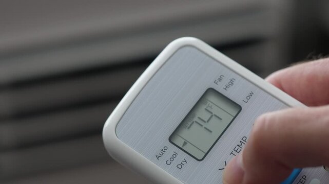 Turning Down Temperature on Thermostat in Summer in Hot Weather. Setting Digital Home Thermostat to Cool and Programming Air Conditioner. Adjusting Room Temperature to Energy Saving in Summer Heat.