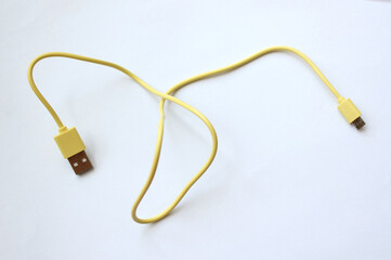 Obraz premium yellow USB cable on white background. USB and USB-mini cable connectors close-up. A patch cable or patch cord or patch lead.