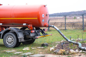 Sewage vacuum truck pumping waste from private house septic tank, liquid waste removal and disposal...