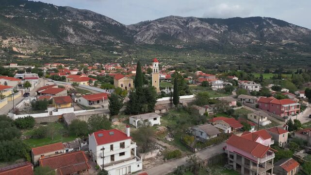 Village with terracotta roofs nestled at the base of a rugged mountain.