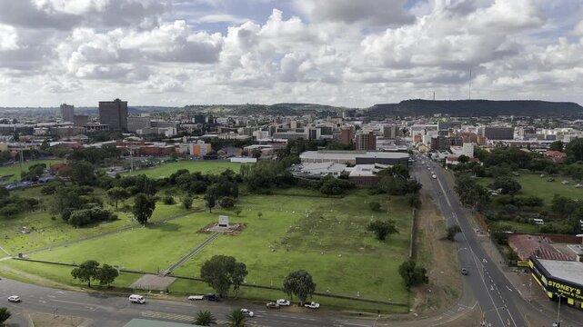 Drone flies north toward Bloemfontein (President Brand) cemetery on partially cloudy afternoon in Bloemfontein, South Africa