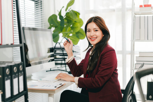 Young Asian woman doing financial accounting and taxes for a company Organizing account analysis reports Investment information Financial and tax system concepts