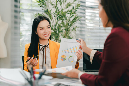 Two female colleagues are consulting and brainstorming. Two female accountants are preparing annual taxes together.