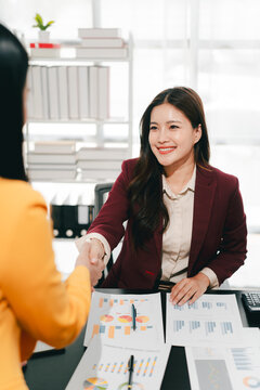 The businesswoman and men shook hands and signed the agreement. This demonstrates teamwork.