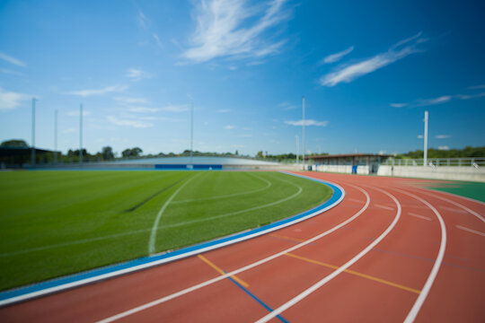 Red running track with white lines and green field