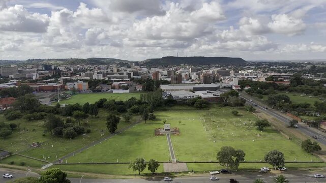 Drone orbits 180 around Bloemfontein (President Brand) cemetery on partially cloudy afternoon in Bloemfontein, South Africa