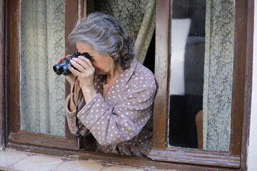 Naklejka premium A woman spying on her neighbours