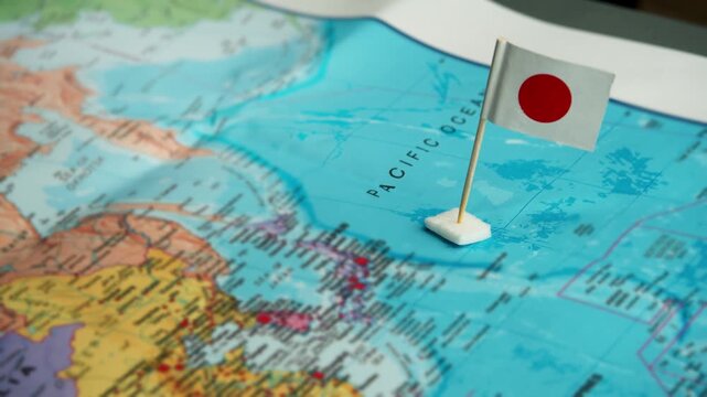 Flag of Japan placed on map highlighting land of samurai and cherry blossoms
