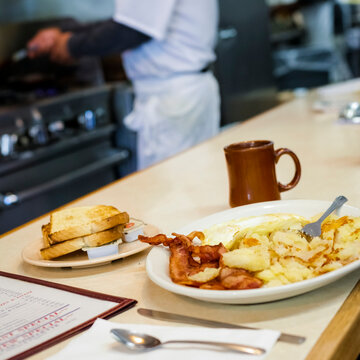 Classic American diner breakfast with eggs bacon and toast at counter