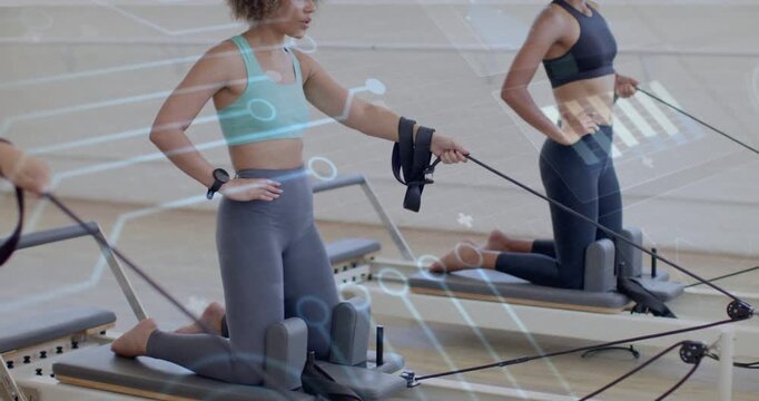 Pullback showing two women kneeling on pilates reformers pulling straps for core with tech overlay