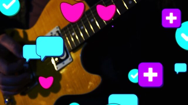 Playing player's hands fretting and plucking amber guitar on stage, with dark sleeve, overlay icons