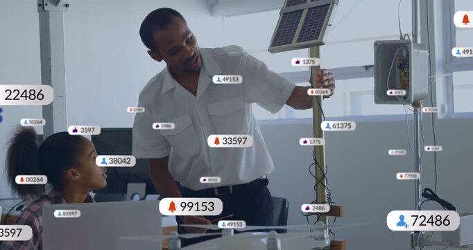 Mentor leaning, pointing at solar panel while student watching laptop overlays appearing education