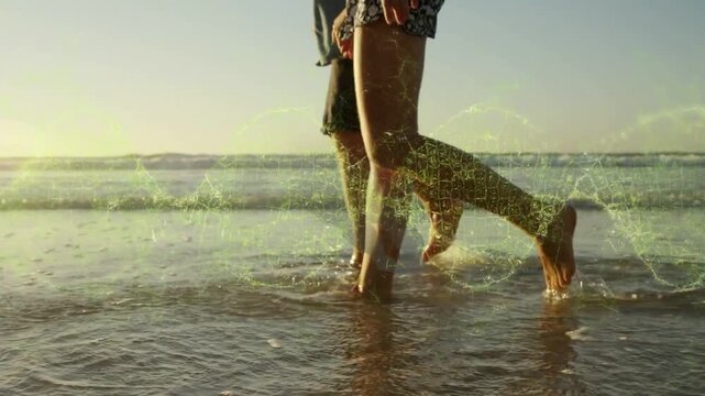 Couple walking shoreline, stepping into water and causing green AR overlay tracing leg motion