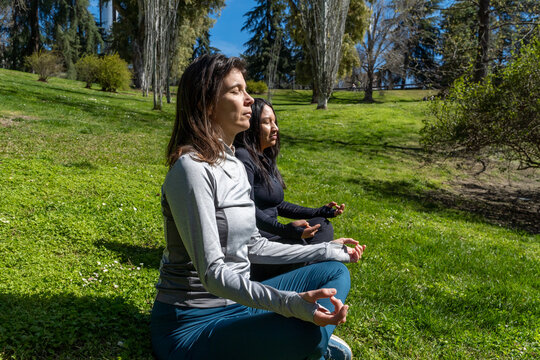 Women practicing mindfulness through meditation in park