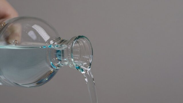 High-resolution taken against plain light grey background focusing solely contents clear transparent glass bot
